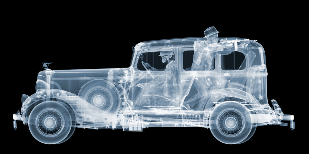 Framed Chromaluxe black and white x-ray photograph by Nick Veasey of a skeleton 1930s gangsters in a pontiac getaway car, pointing a vintage machine gun