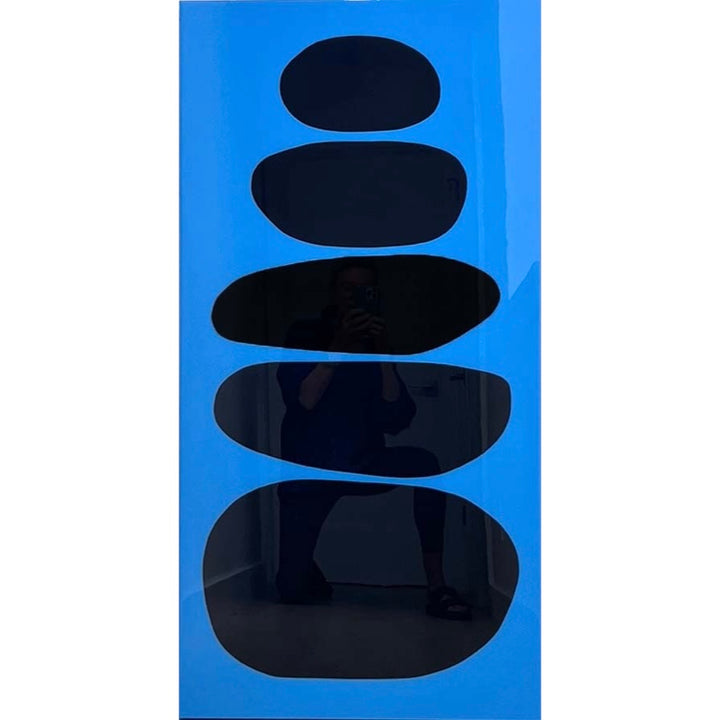 five black organic circular shapes in vertical composition stacked on top of each other, large at the bottom and smaller as they go up on blue background