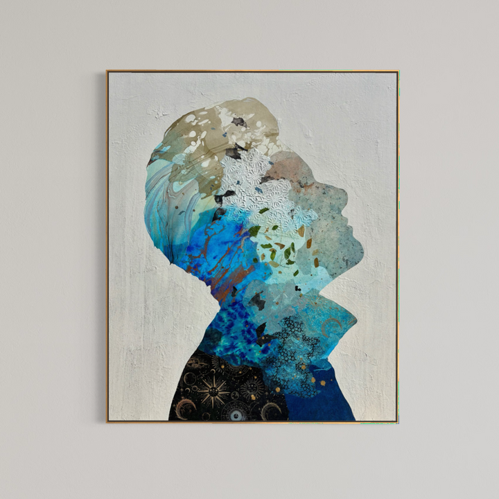 Christopher Peter, Born to Be Blue, acrylic, oil, handmade papers and gold leaf on canvas, 48 x 40 inches. The painting shown in a thin gold-toned frame on a light gray wall, depicting an upward-facing profile silhouette filled with blue, turquoise, tan, and black collaged papers on a textured off-white background.