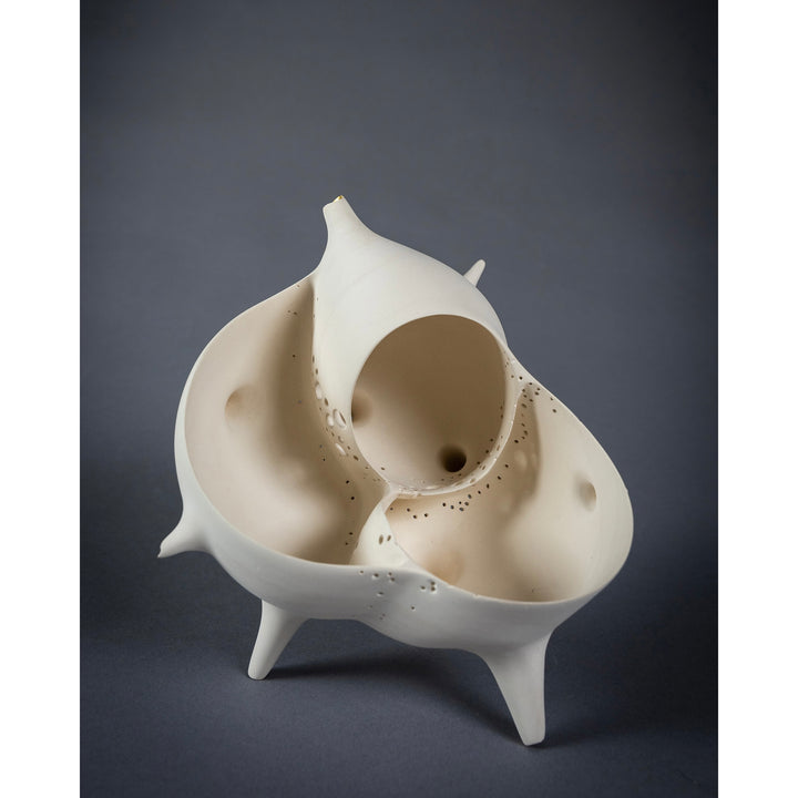 Ceramic abstract shaped vessel like sculpture with legs curved  and open ides holes gold leaf