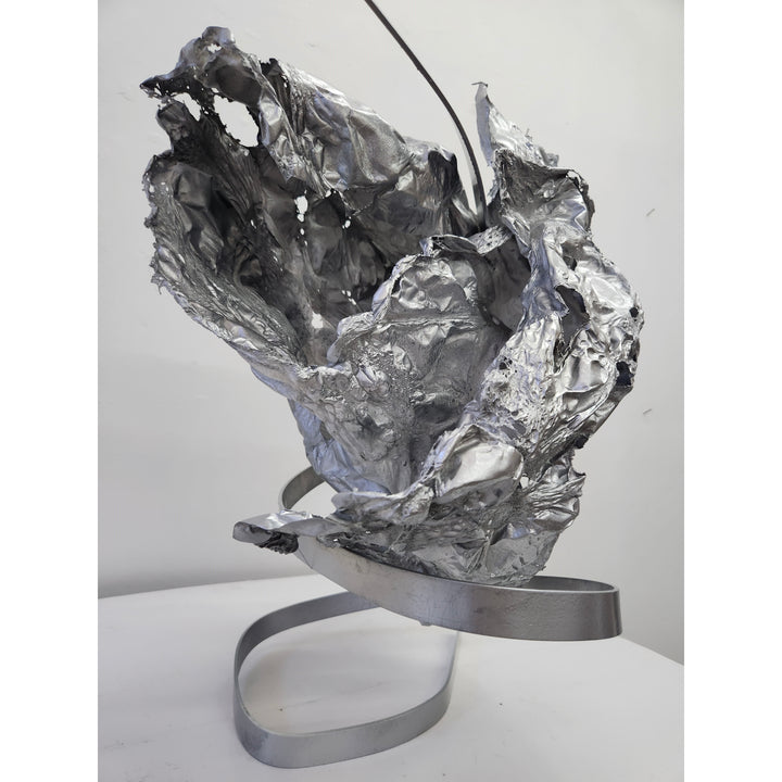 metal sculpture organic abstract shape with holes wrinkles and spiral stand in silver