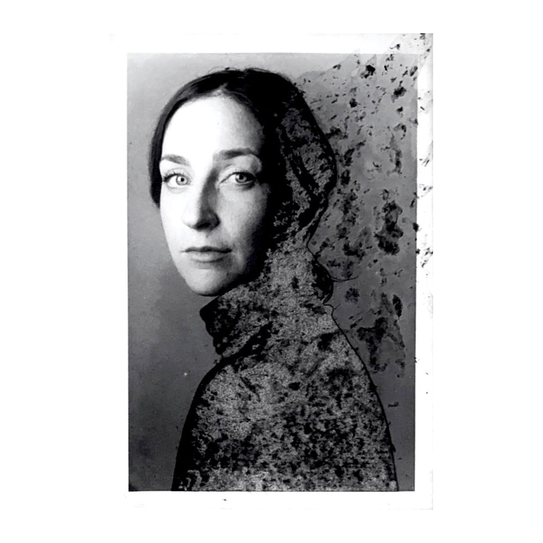 small profile portrait woman with dark hair looking at viewer, sweater fading off into distance black and white