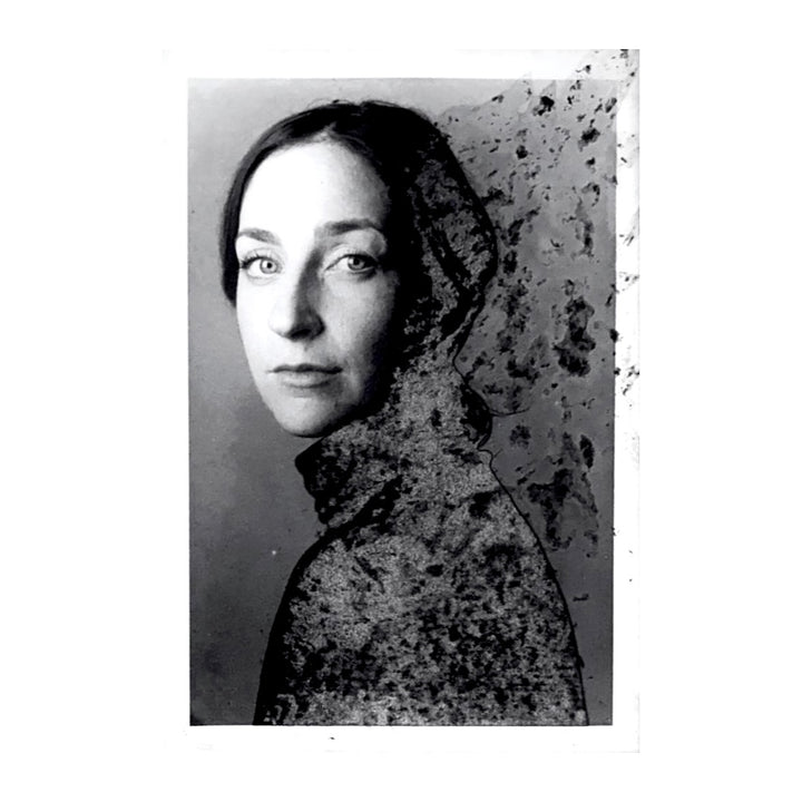small profile portrait woman with dark hair looking at viewer, sweater fading off into distance black and white