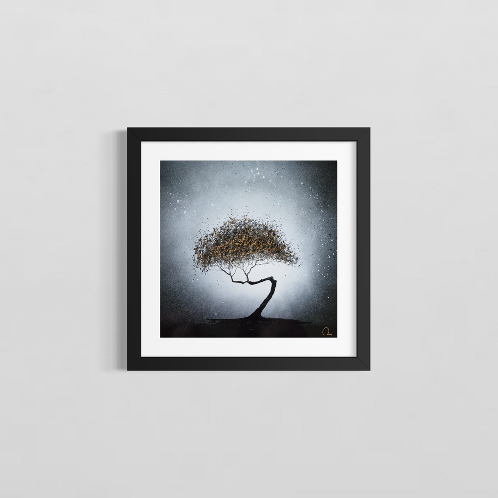 "Golden Light" by French artist Julien Rey — a mixed-media painting on board of a solitary windswept tree, crafted with Chinese lacquer and gold leaf. A dramatically curved black trunk bends gracefully beneath an expansive canopy of gold leaf and dark lacquer foliage, set against a luminous silver-gray sky dusted with delicate white droplets evoking snow or starlight. Original contemporary gold leaf tree painting on board available at Morton Contemporary gallery.