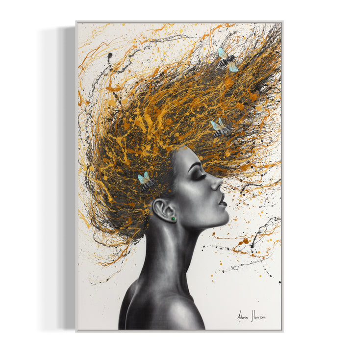Profile of a woman painted in coconut charcoal, flipping her hair, splattered gold and orange paint with honey bees