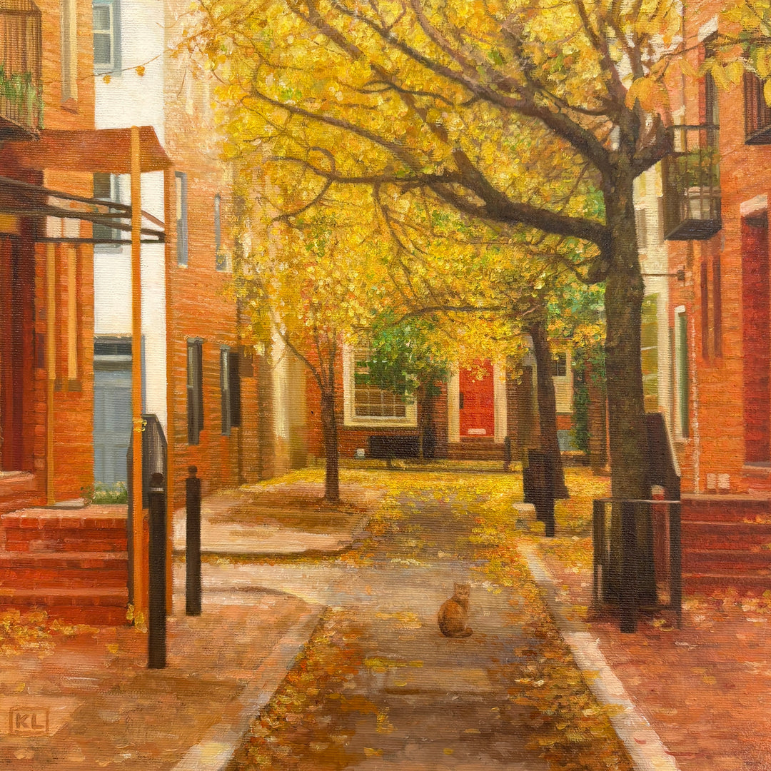 Oil painting of a residential street with brick townhomes, in yellow and orange, small cat sitting in the center of the street with golden leaves falling from the trees