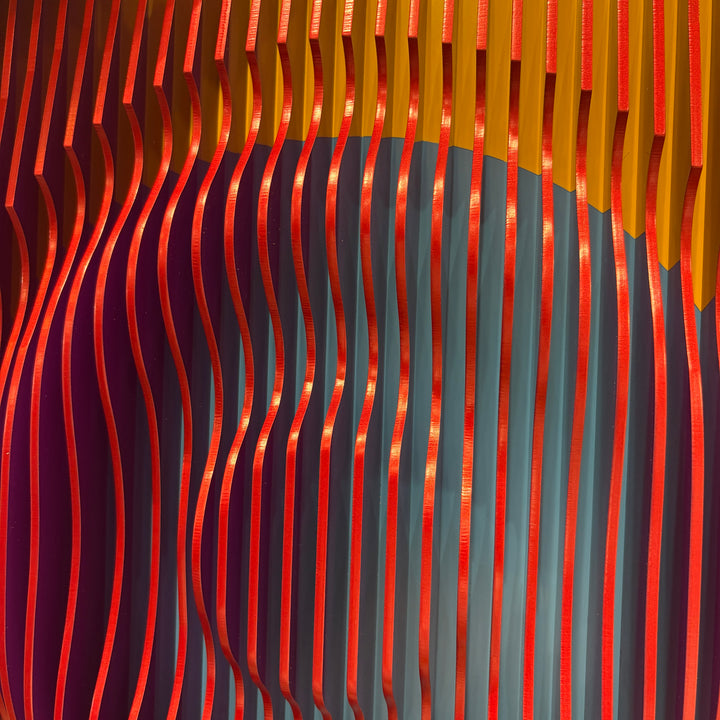 vertical stripes plexiglass abstract geometric with yellow and orange in back and pulsing round circular middle in blue when viewed at angle mostly red