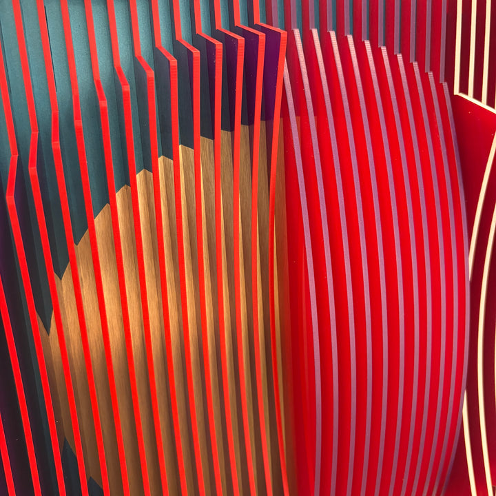 3 dimensional circular shape in center of vertical stripes square composition in red and blue white then when turned to side mostly red emerges optical illusion space color