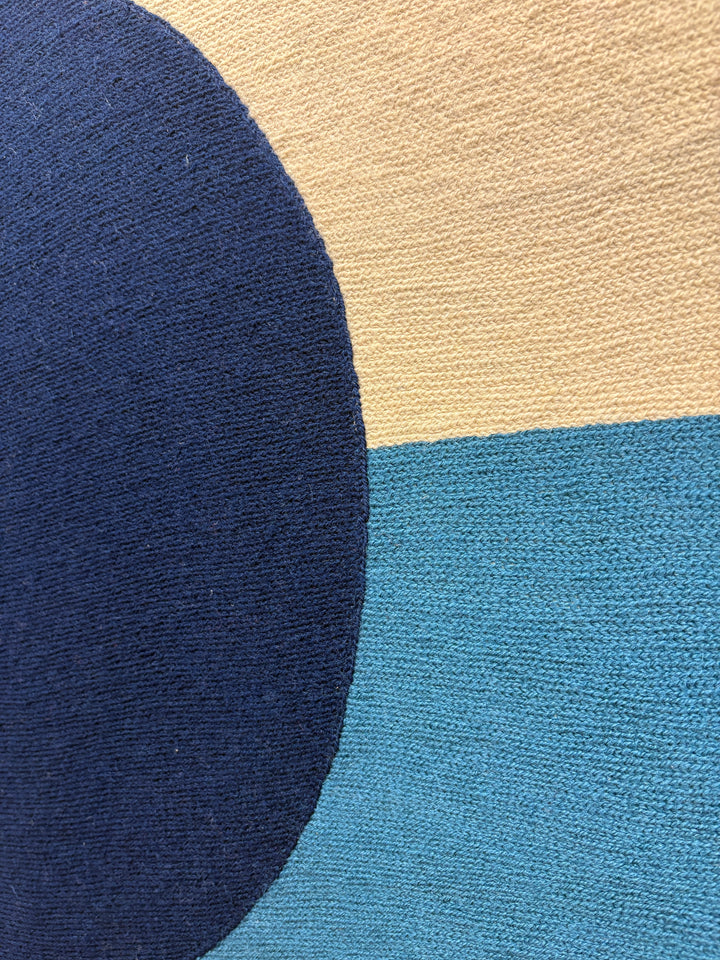 chain stitched embroidery textile fabric framed abstract geometric blue dot split composition negative space white and blue with orange wave in foreground