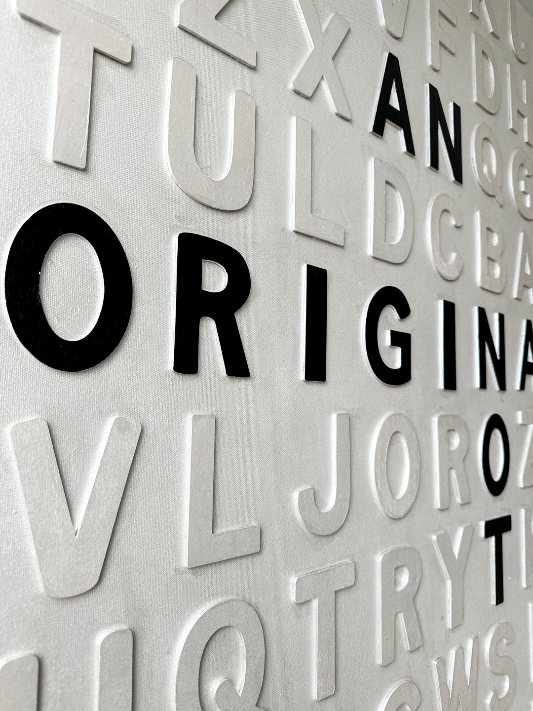 Contemporary 3D text artwork by Chicago artist Steffanie Gerkin titled I’m an Original 3D, featuring raised black and white wood letters arranged in a structured alphabet grid on a white canvas. The monochrome typographic composition spells the phrase “I’m an Original, Not a Print,” creating a bold conceptual wall art piece with graphic text-based design, pop art influence, and contemporary mixed-media style.