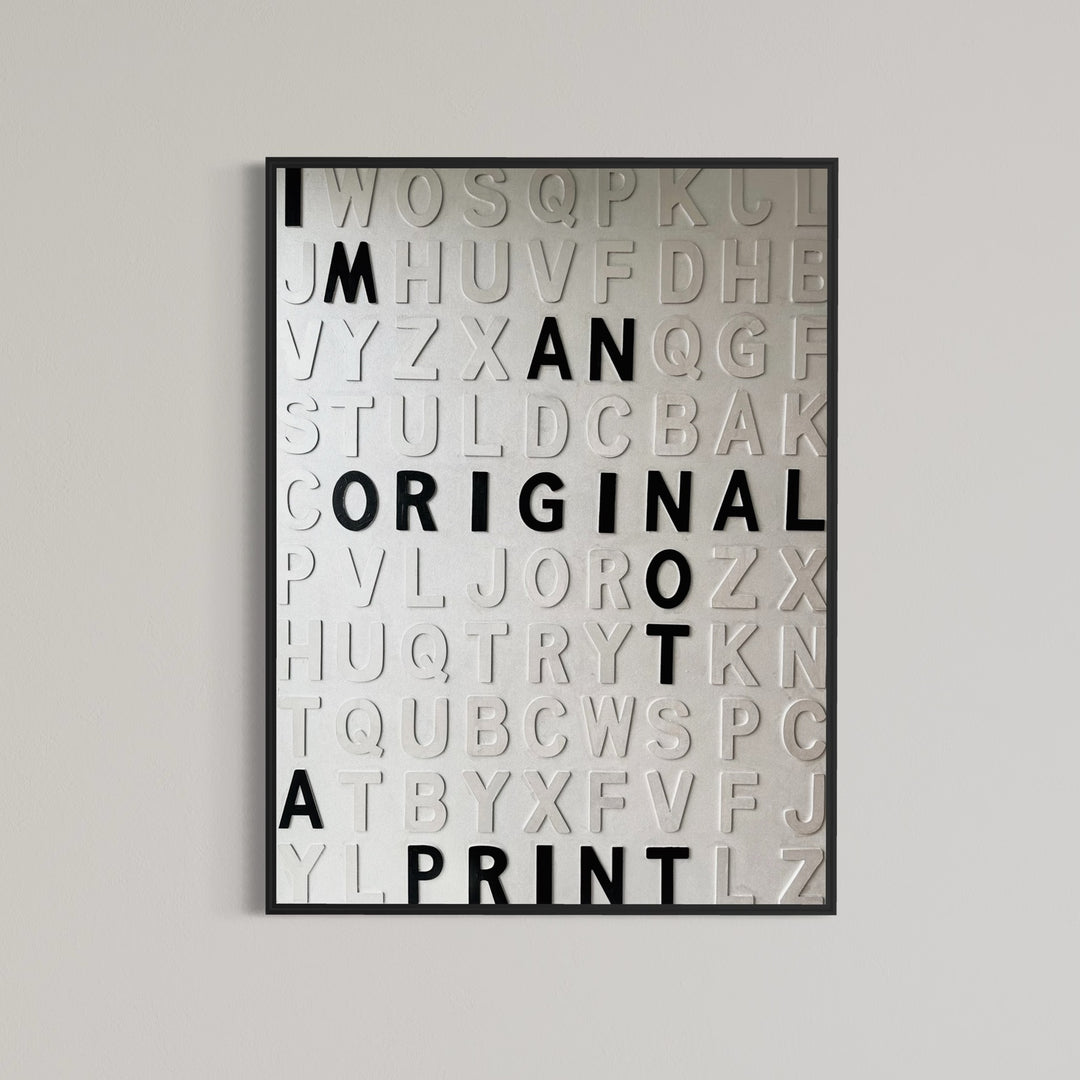 Contemporary 3D text artwork by Chicago artist Steffanie Gerkin titled I’m an Original 3D, featuring raised black and white wood letters arranged in a structured alphabet grid on a white canvas. The monochrome typographic composition spells the phrase “I’m an Original, Not a Print,” creating a bold conceptual wall art piece with graphic text-based design, pop art influence, and contemporary mixed-media style.