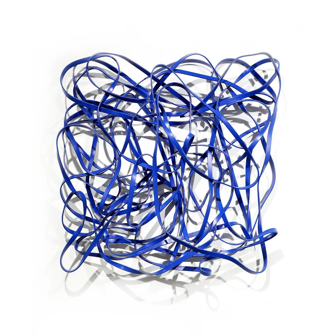 Matt Devine, 1984, powder-coated aluminum, made to order from 11 to 84 inches. Square wall sculpture of thin blue aluminum ribbons bent into tangled, overlapping loops on a white wall.