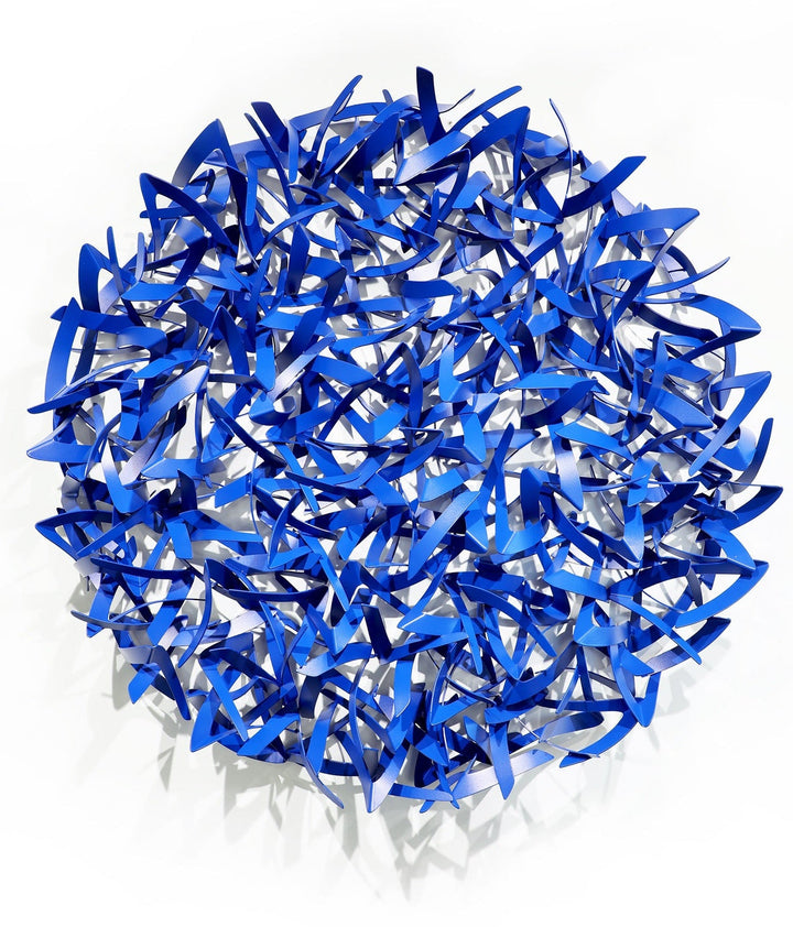 Matt Devine, Avian, powder-coated aluminum, made to order from 11 to 84 inches. Round wall sculpture of many small, curved cobalt blue aluminum pieces shaped like bird wings, interlocked in a dense cluster on a white wall.