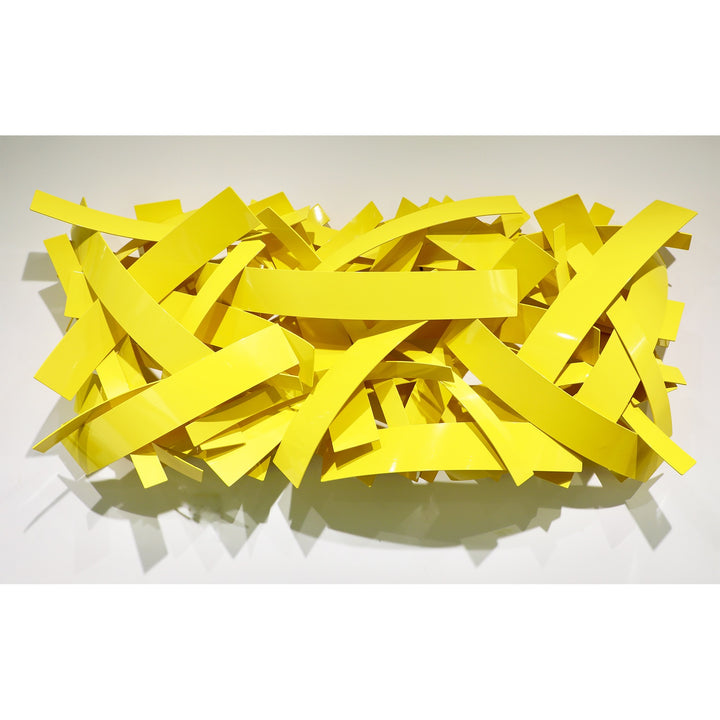 Matt Devine, Mixed Bands, powder-coated aluminum, made to order from 11 to 84 inches. Horizontal rectangular wall sculpture of flat yellow aluminum bands in mixed widths, layered in a crisscross pattern on a white wall.