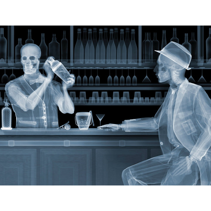 Framed Chromaluxe black and white x-ray photograph by Nick Veasey of two skeletons. A bar tender making a cocktail for a customer sitting at a bar with glasses and bottles behind them