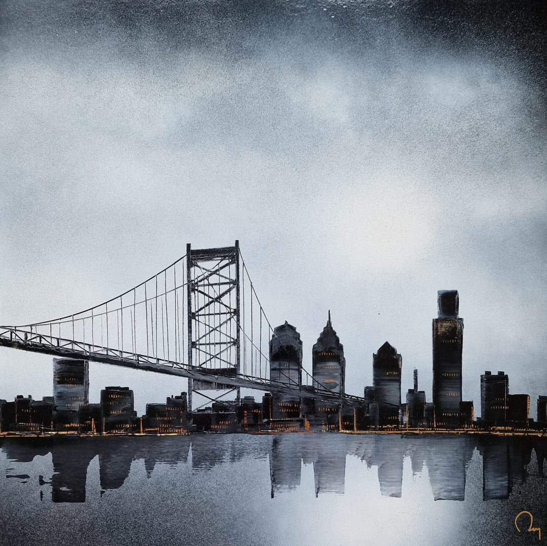 "Philly Wakes Up" by French artist Julien Rey — a mixed-media painting on board of the Philadelphia skyline at dawn, crafted with Chinese lacquer and gold leaf. The Benjamin Franklin Bridge spans dramatically across the composition, its cables and towers reflected in the still Delaware River below. Iconic skyscrapers glow with subtle gold leaf accents beneath a brooding silver-gray sky. Original contemporary Philadelphia bridge and skyline painting on board available at Morton Contemporary gallery.