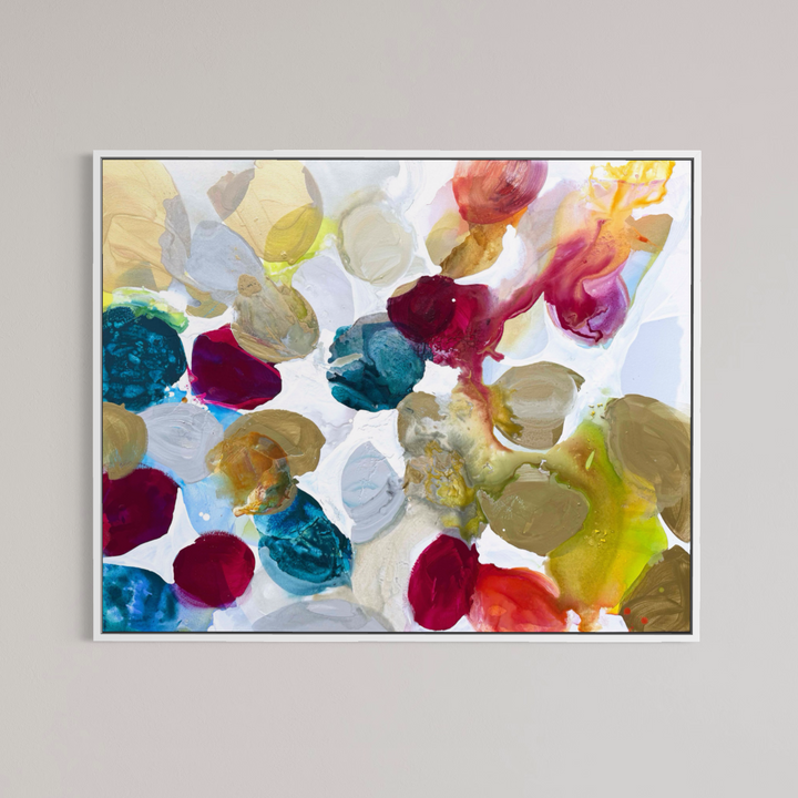 Liz Barber, Spring Dream, acrylic paint, ink, and watercolor on canvas, 60 x 48 inches. Abstract composition of rounded shapes in gold, taupe, deep crimson, teal, pale blue, and white with red-orange and chartreuse ink washes on a white background, shown in a thin white frame on a light gray wall.