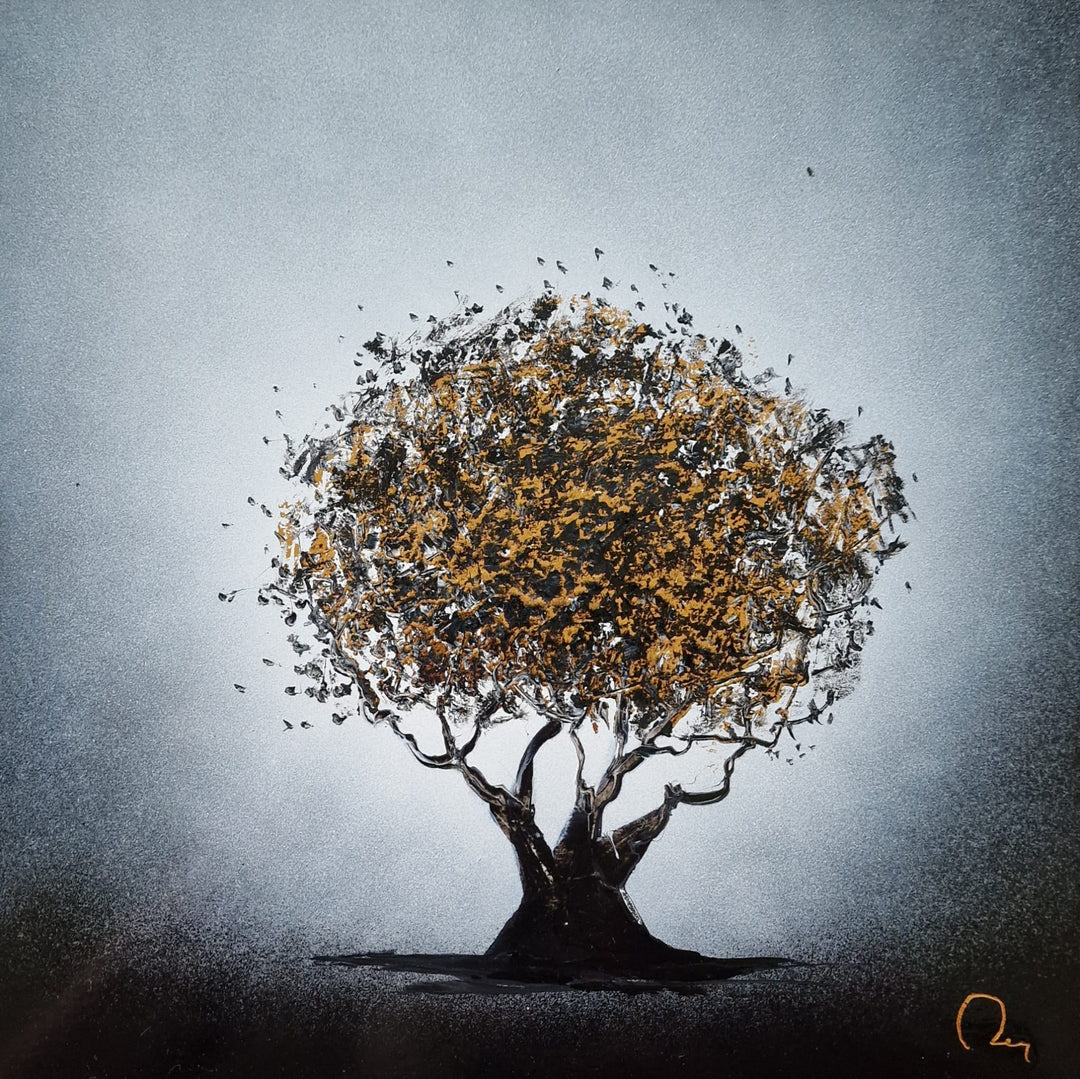 "Un Petit Olivier" by French artist Julien Rey — a mixed-media painting of a solitary olive tree crafted with Chinese lacquer and gold leaf on canvas. A full, rounded canopy bursting with gold leaf and dark lacquer foliage crowns two intertwining black trunks, rooted in a shadowy earth against a soft silver-gray atmospheric background. Evokes the timeless beauty of the Mediterranean landscape. Original contemporary olive tree painting available at Morton Contemporary gallery.