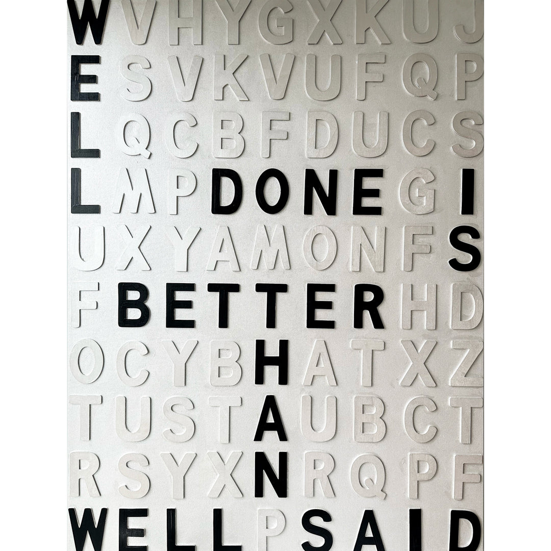 Contemporary 3D text artwork by Chicago artist Steffanie Gerkin titled Well Done 3D, featuring raised black and white wood letters arranged in a structured alphabet grid on a white canvas. The monochrome typographic composition spells the phrase “Well Done Is Better Than Well Said,” creating a bold conceptual wall art piece with graphic text-based design, pop art influence, and contemporary mixed-media style.